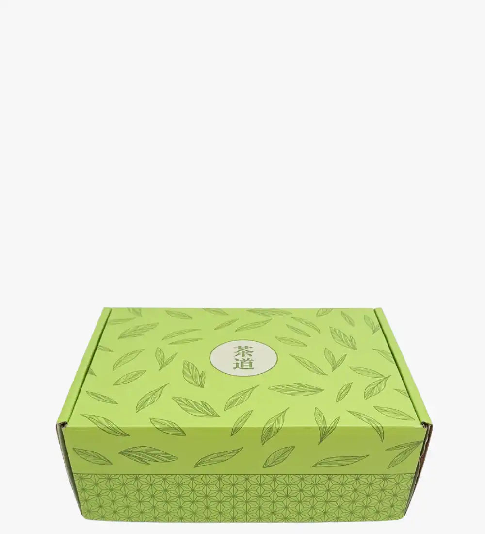 Boîte de thé à motif de feuilles vertes avec un logo circulaire.